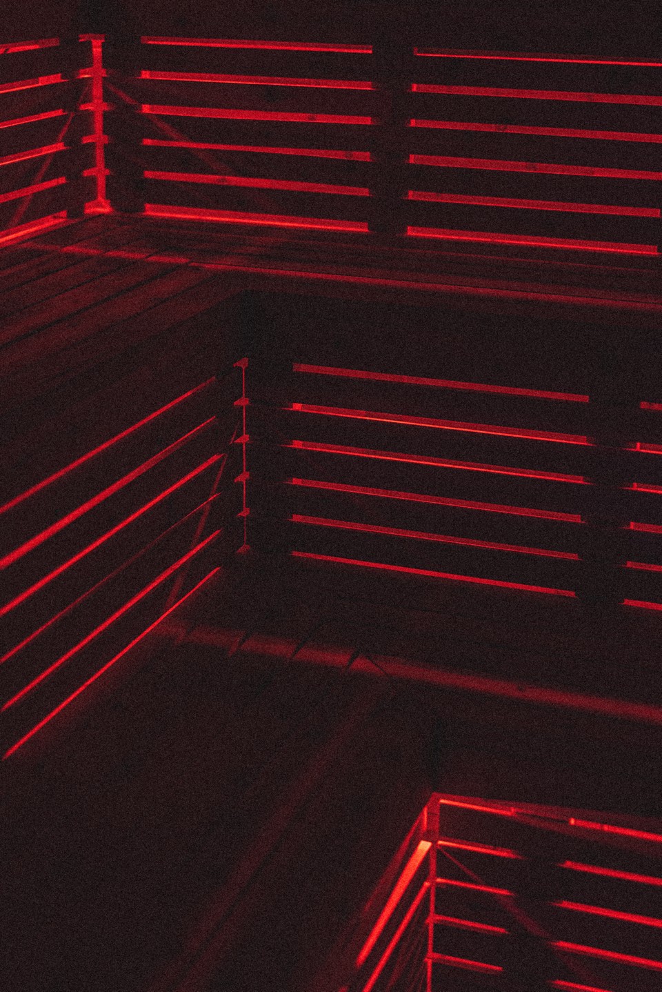 The sauna at The Den Waialua, lit red along the slatted benches